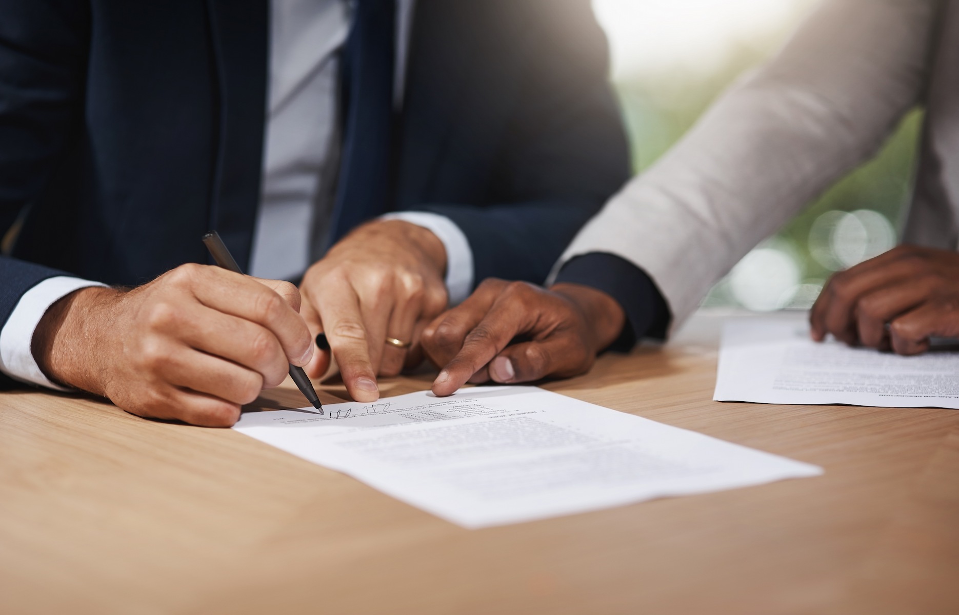 Professionals reviewing and signing company formation documents in a Dubai free zone, so they can receive their certificate of incorporation.