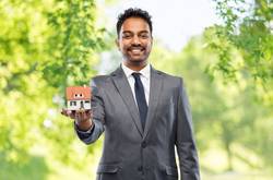 Business Man Holding House Model