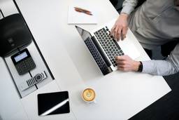 stock photo man working at desk with MacBook and coffee